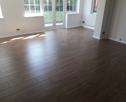 Redhill living area with oak effect laminate flooring leading to French doors and garden access