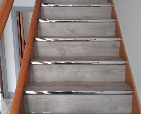 LVT flooring on stairs in Surrey fitted with chrome stair nosing and warm grey whitewashed finish