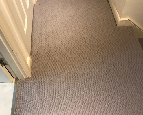 Light soft grey wool loop berber carpet in first floor hallway in Reigate, leading to rooms with wooden flooring