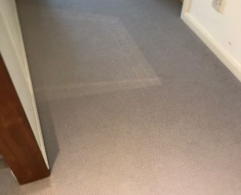 Another view of the soft grey wool loop berber carpet in Reigate hallway with wooden flooring accents