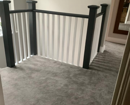 Charcoal grey velvet carpet installed on large open landing in Surrey home with natural light from large first floor window