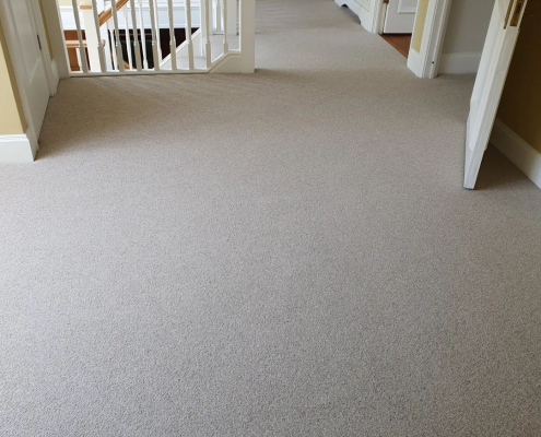 Wool loop oat coloured carpet on a large open light filled landing in a Surrey home