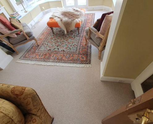 Wool loop carpet in oat colour in a bright Surrey lounge leading to a garden through French doors