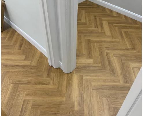 Seamless herringbone LVT flooring flowing between rooms in a Surrey home