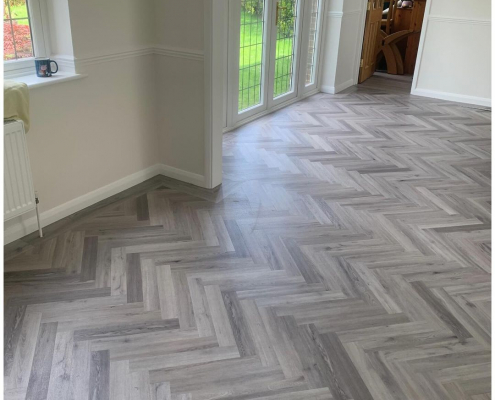 Open plan living space in Redhill Surrey with light grey herringbone LVT flooring flowing between rooms and garden doors