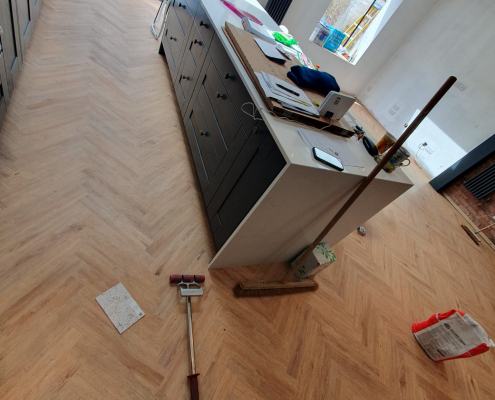 Project Floors golden oak herringbone LVT flooring installed in a modern kitchen area in Surrey with clean lines and open layout