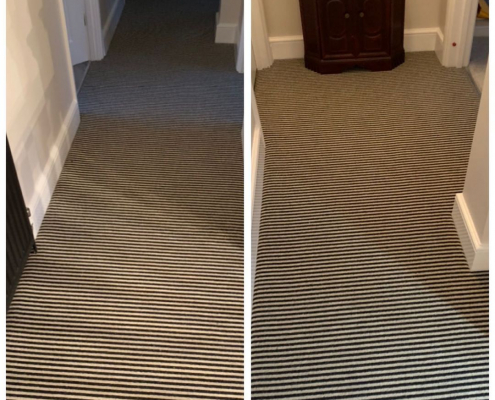 Black and white striped wool-mix Berber carpet fitted along a bright hallway and return staircase, complemented by a black wooden handrail and white walls in a Redhill, Surrey home.
