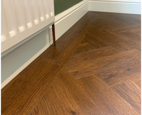 Detail of border design around Amtico herringbone LVT flooring installation in Redhill living room