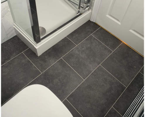 Grey graphite LVT flooring in brick pattern with white strips in Redhill bathroom showing shower enclosure