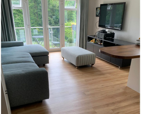French Oak LVT flooring in Surrey apartment lounge with natural light and balcony view