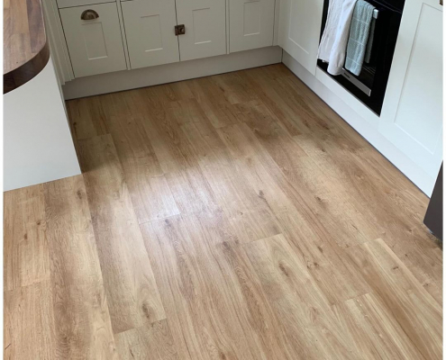 French Oak plank LVT flooring in a modern Surrey apartment kitchen with cream shaker units