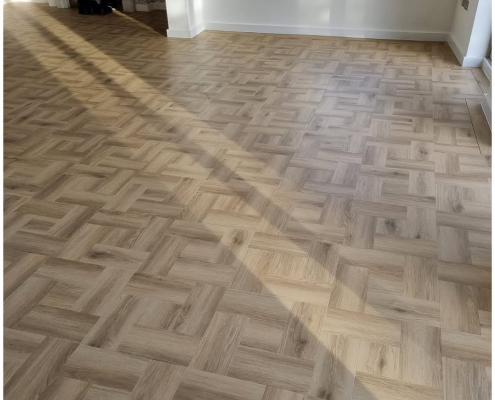 View into Reigate living room showing Amtico Signature Wild Walnut and Cornish Oak LVT basket weave floor with border