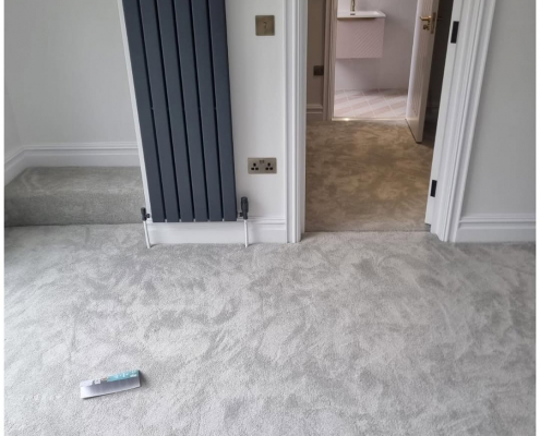 Reigate bedroom and walk-in wardrobe with soft grey carpets installed