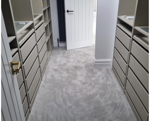 Reigate walk-in wardrobe with light grey soft carpet installed