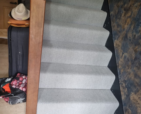Ground floor view of Surrey staircase with flatweave herringbone carpet installed