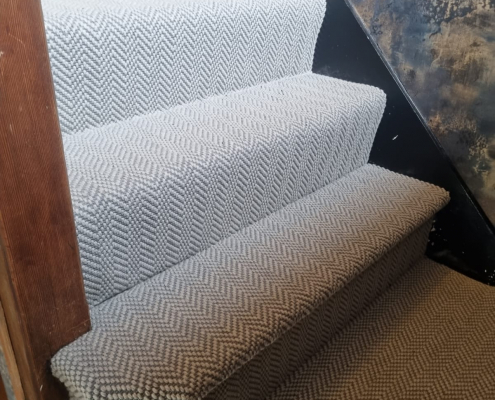 Side view of Surrey staircase with flatweave herringbone carpet on the steps