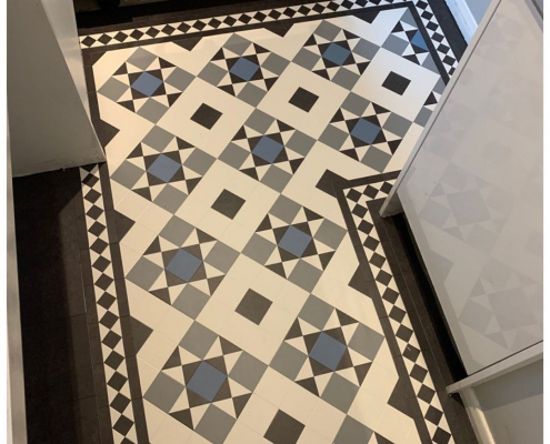 Kitchen with bespoke traditional tile heritage LVT flooring in black, white, grey, and blue tiles