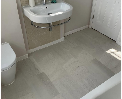 Surrey bathroom with light grey stone-effect LVT flooring installed, first view