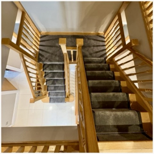 Surrey home double staircase featuring grey carpet runner, taped edges and chrome stair rods