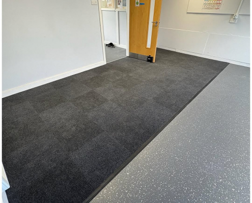 Classroom with dark carpet and grey safety flooring installed