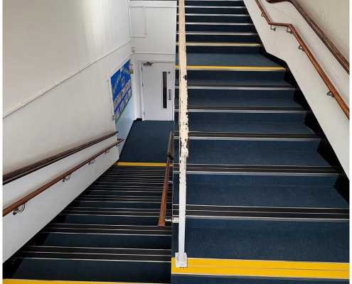 School stairwell with blue carpet and nosing