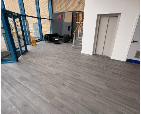 Bright office entrance lobby in Kent with grey oak-effect commercial LVT flooring installed