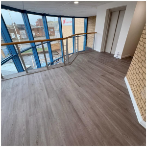 Bright mezzanine landing with oak-effect commercial LVT flooring in a Kent business