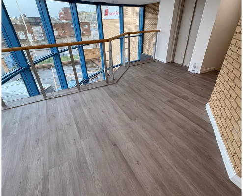 Bright mezzanine landing with oak-effect commercial LVT flooring in a Kent business