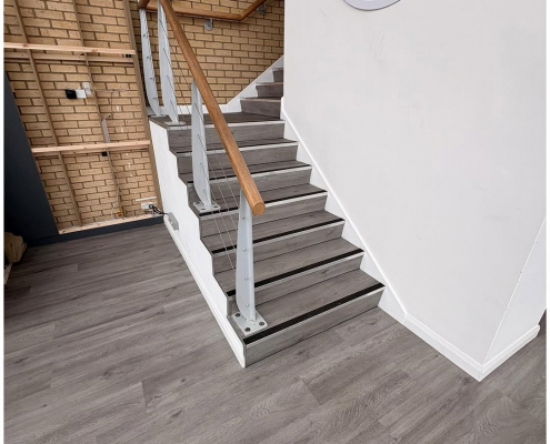 Office hallway and stairs in a Kent commercial building with grey oak LVT flooring and safety nosing installed