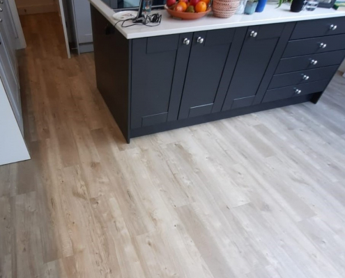 Kitchen fitted with sun bleached oak LVT flooring Reigate open plan kitchen diner with light sun bleached oak LVT flooring viewed midway from dining area towards kitchen
