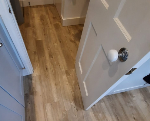 Cloakroom fitted with sun bleached oak LVT flooring Cloakroom in Reigate home fitted with light sun bleached oak LVT flooring and modern compact design