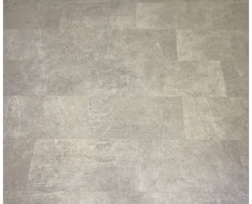 Stone effect LVT flooring Close-up of cement stone-effect LVT flooring installed in a Surrey kitchen