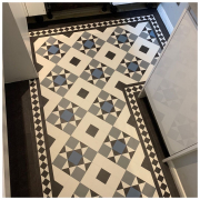 Kitchen with bespoke traditional tile heritage LVT flooring in black, white, grey, and blue tiles