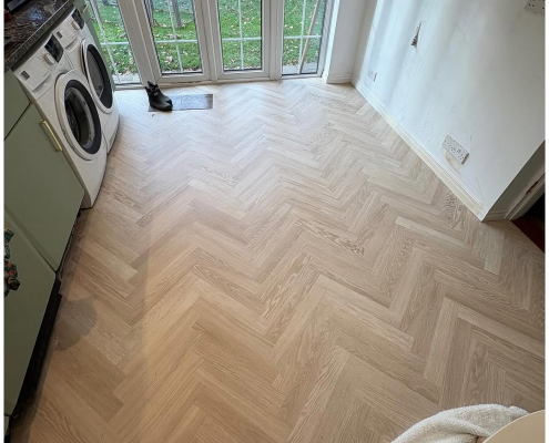 Kitchen light oak herringbone LVT installation Kitchen in Redhill with light oak herringbone LVT flooring and garden view