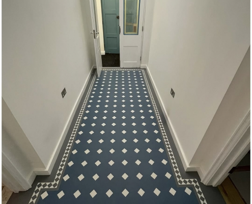 Karndean Heritage LVT Entrance Hallway Installation Karndean Heritage LVT flooring installed in a bright Reigate entrance hallway with white walls and white glazed double doors, featuring blue and white diamond tiles with a grey border and inset diamond detailing.