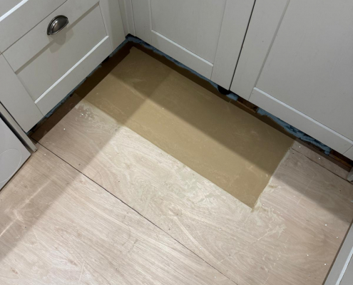 Kitchen Subfloor Preparation with Feather Finish Kitchen subfloor preparation using plywood and feather finish smoothing compound before laminate flooring installation.