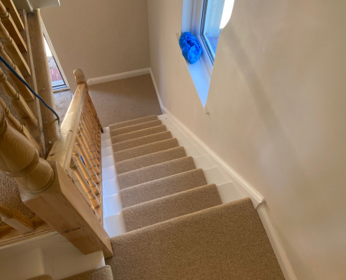 Beige Wool Loop Stair Runner on Oak Staircase Beige wool loop Berber carpet runner on oak staircase with white painted steps and fully carpeted landing